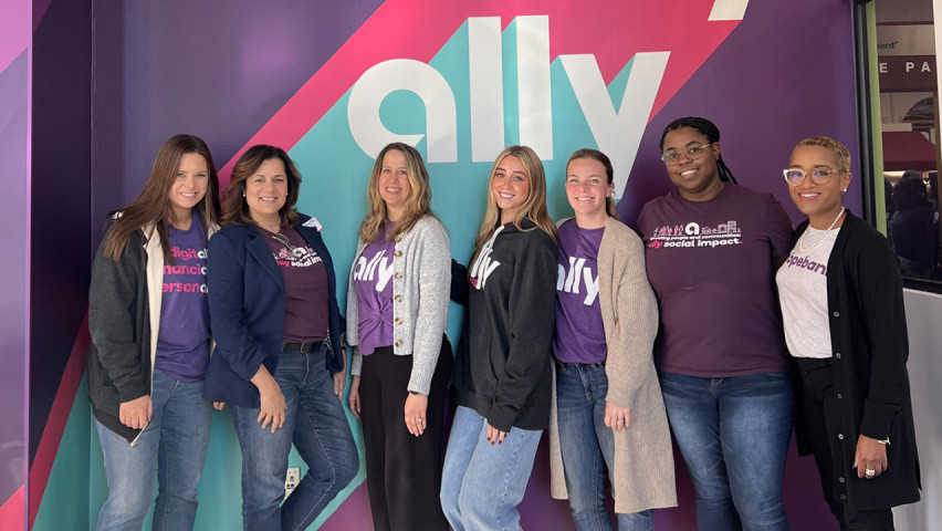 Group of women posing in front of Ally sign